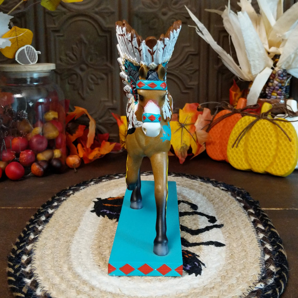Resin pony painted brown and white with Native American motifs and a traditional headdress.