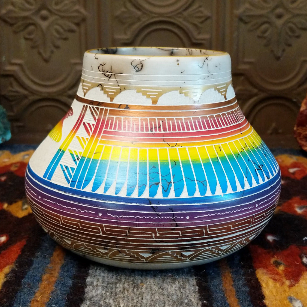 Pot showing rainbow layers and horsehair texture on white clay.