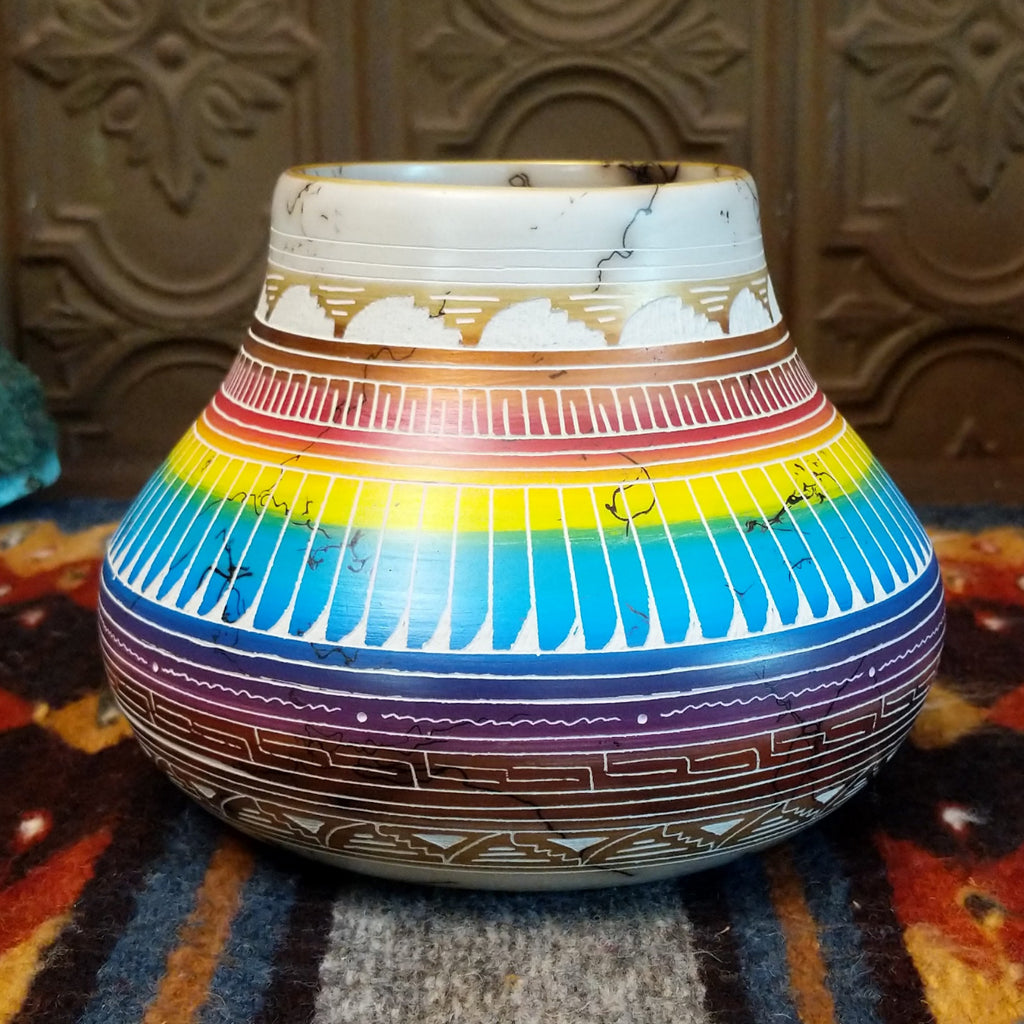 Pot showing rainbow layers and horsehair texture on white clay.