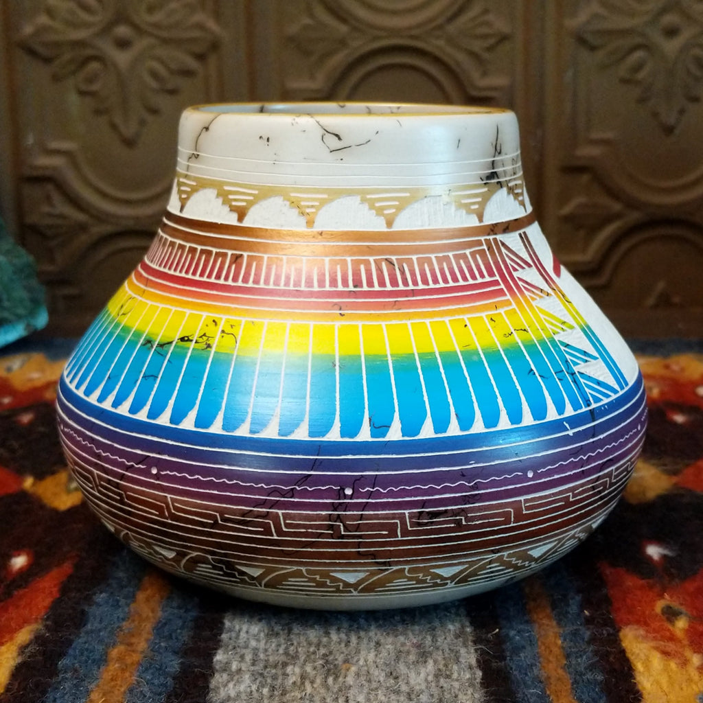 Pot showing rainbow layers and horsehair texture on white clay.