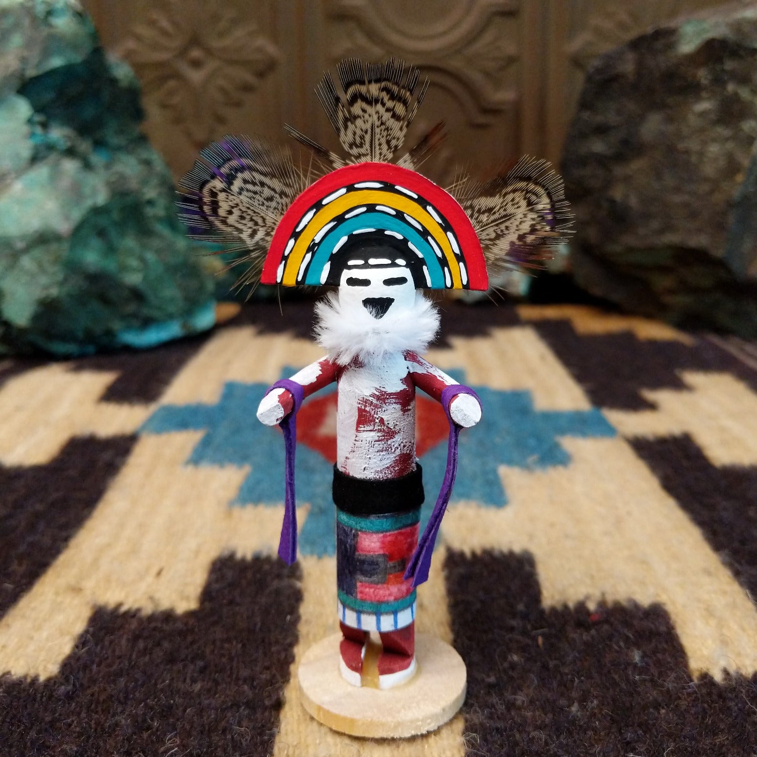 Mini rainbow kachina by Rosalind Grey with multicolored rainbow headdress, patterned feathers, white face, and feather collar.