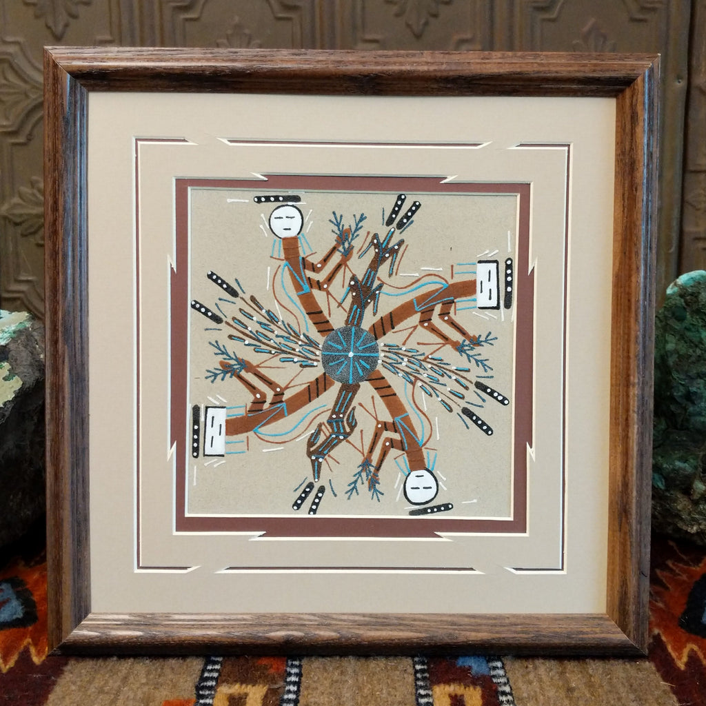 Multicolored sand used to depict Rainbow people set within a wooden frame.