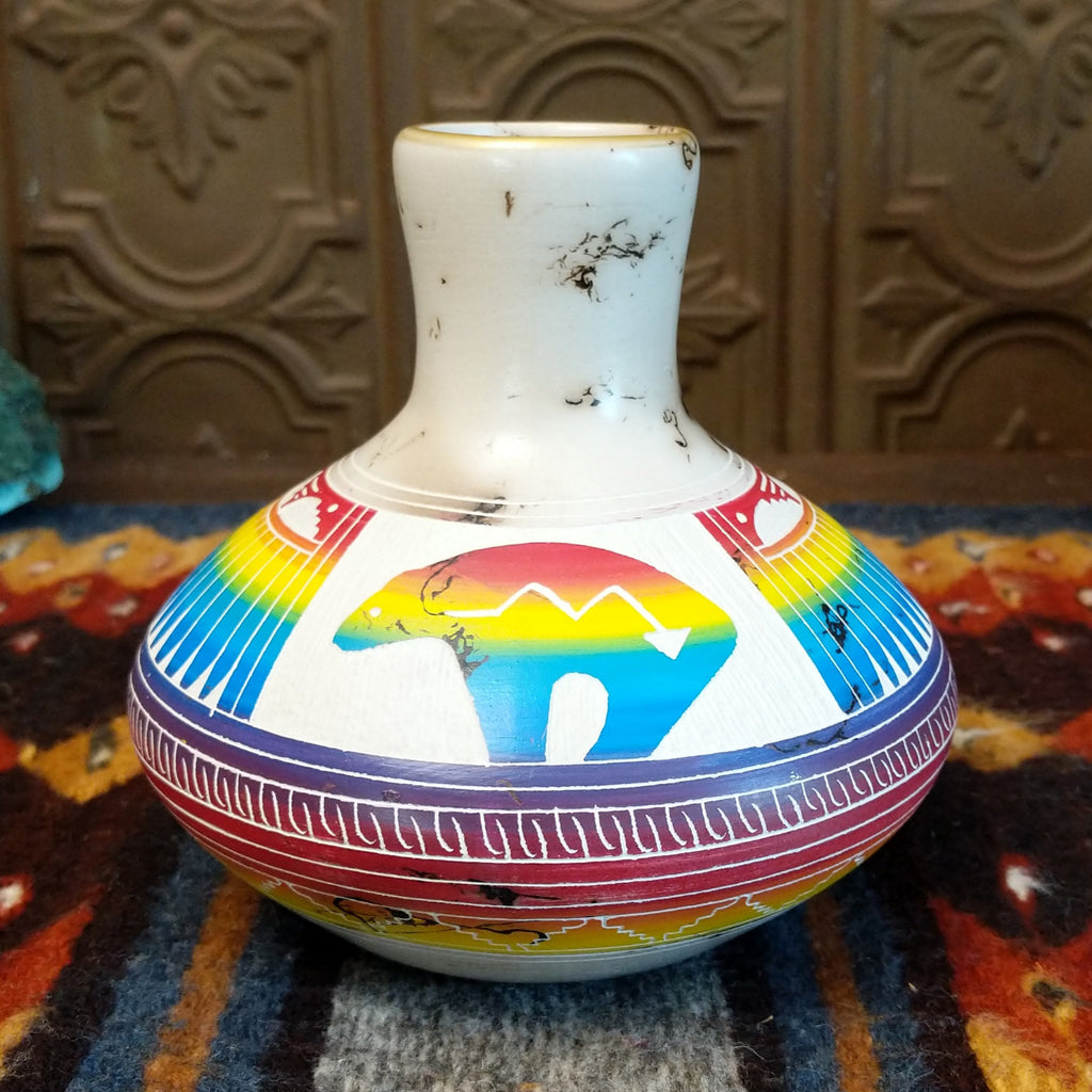 Horsehair pottery with white clay, rainbow stripes, and a spirit bear design.