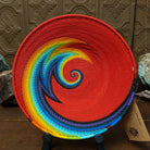 Handwoven rainbow wire art basket by Bridge for Africa featuring colorful recycled wire in a vibrant geometric pattern, ideal as a decorative bowl or wall display.