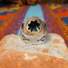 Raised #8 Turquoise Ring by Chris Billie featuring an oval turquoise stone centered within a raised silver flower, surrounded by detailed stamped and oxidized silverwork on a wide band; underside view.