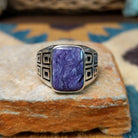 Handcrafted Navajo sterling silver ring by Terry Wood featuring a raised rectangular charoite cabochon with natural purple swirling patterns, set in a polished silver bezel with geometric detailing on the band.