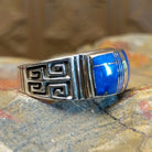 Sterling silver ring with lapis inlaid on the raised bezel and geometric designs on the band.