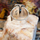 Sterling silver ring with sugilite set in a raised bezel with twisted rope accents, and a polished finish.