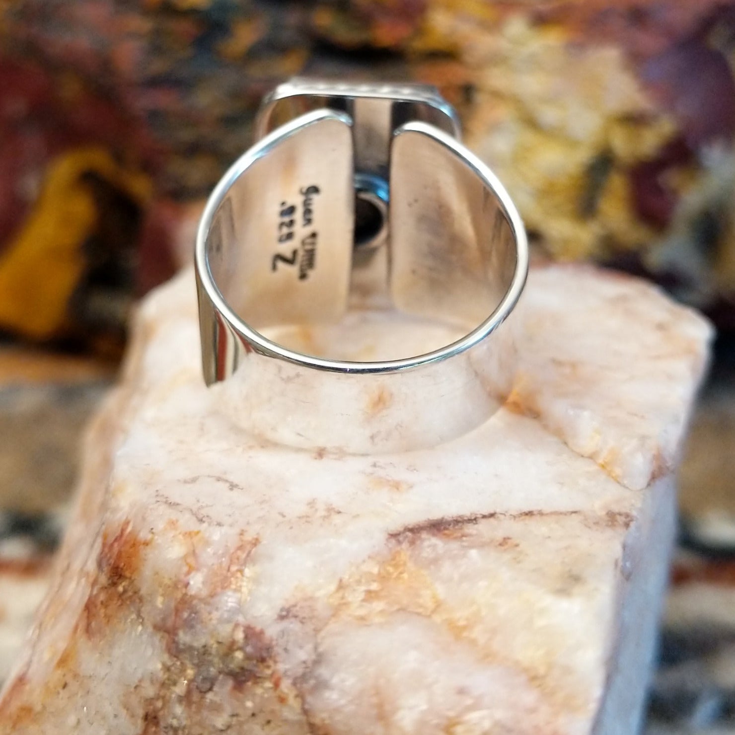 Sterling silver ring with sugilite set in a raised bezel with twisted rope accents, and a polished finish.