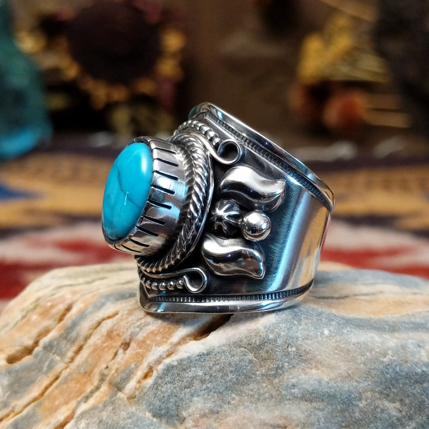 Handcrafted Navajo sterling silver ring by Murphy Platero featuring a raised oval turquoise stone surrounded by twisted wire, beadwork, and traditional Southwestern silver detailing.  Side view.