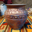 Round raku pottery vase by Roger Calhoun with a flared rim, raised geometric bands, and a metallic copper, bronze, and smoky brown finish.
