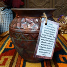 Round raku pottery vase by Roger Calhoun with a flared rim, raised geometric bands, and a metallic copper, bronze, and smoky brown finish.