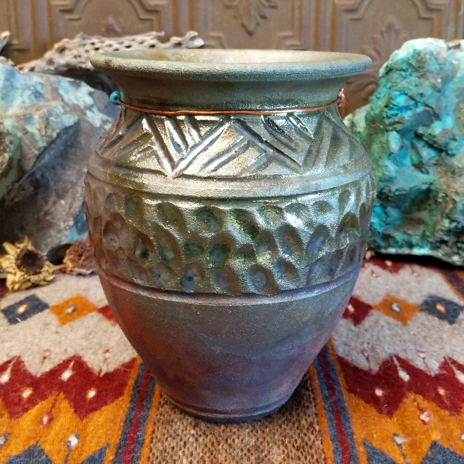 Raku pottery with geometric designs and oxidized copper appearance.