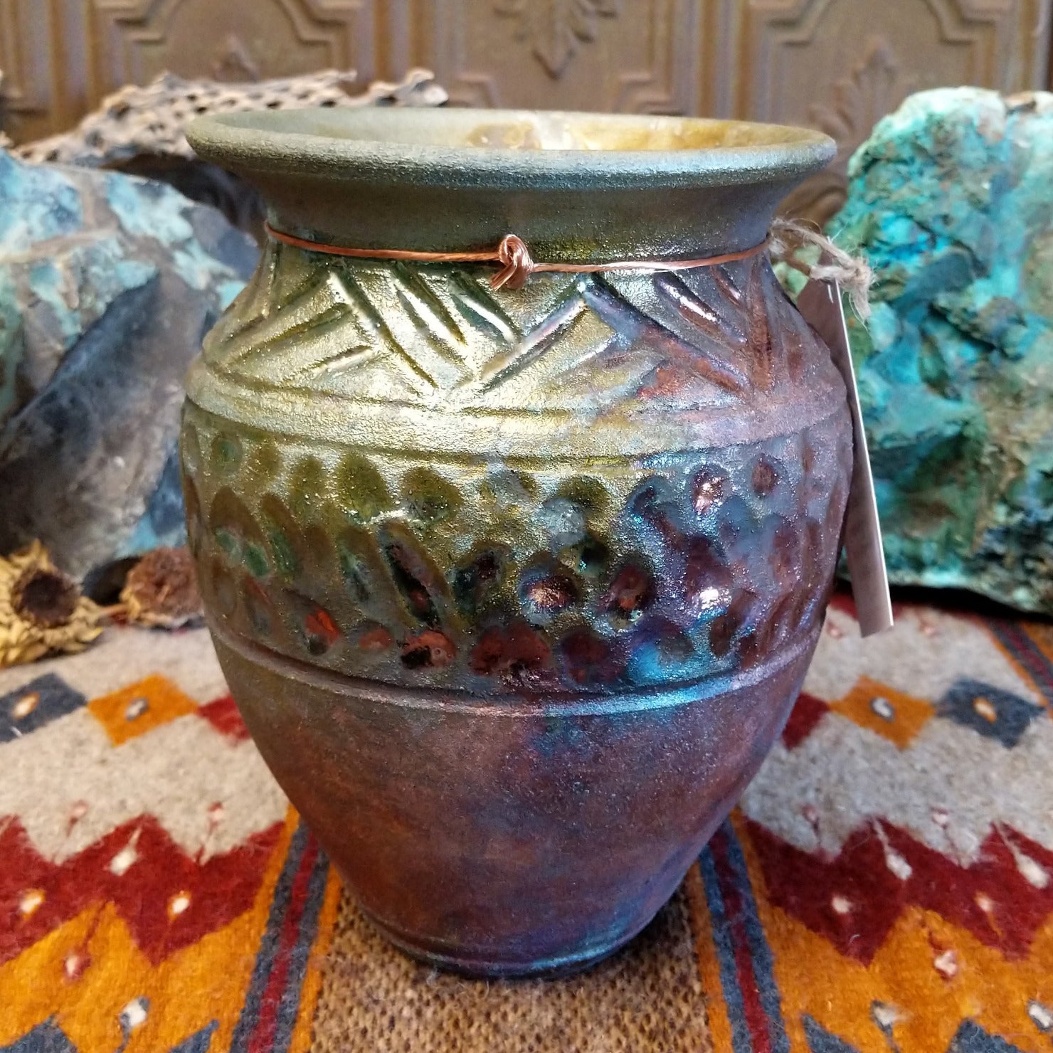 Raku pottery with geometric designs and oxidized copper appearance.