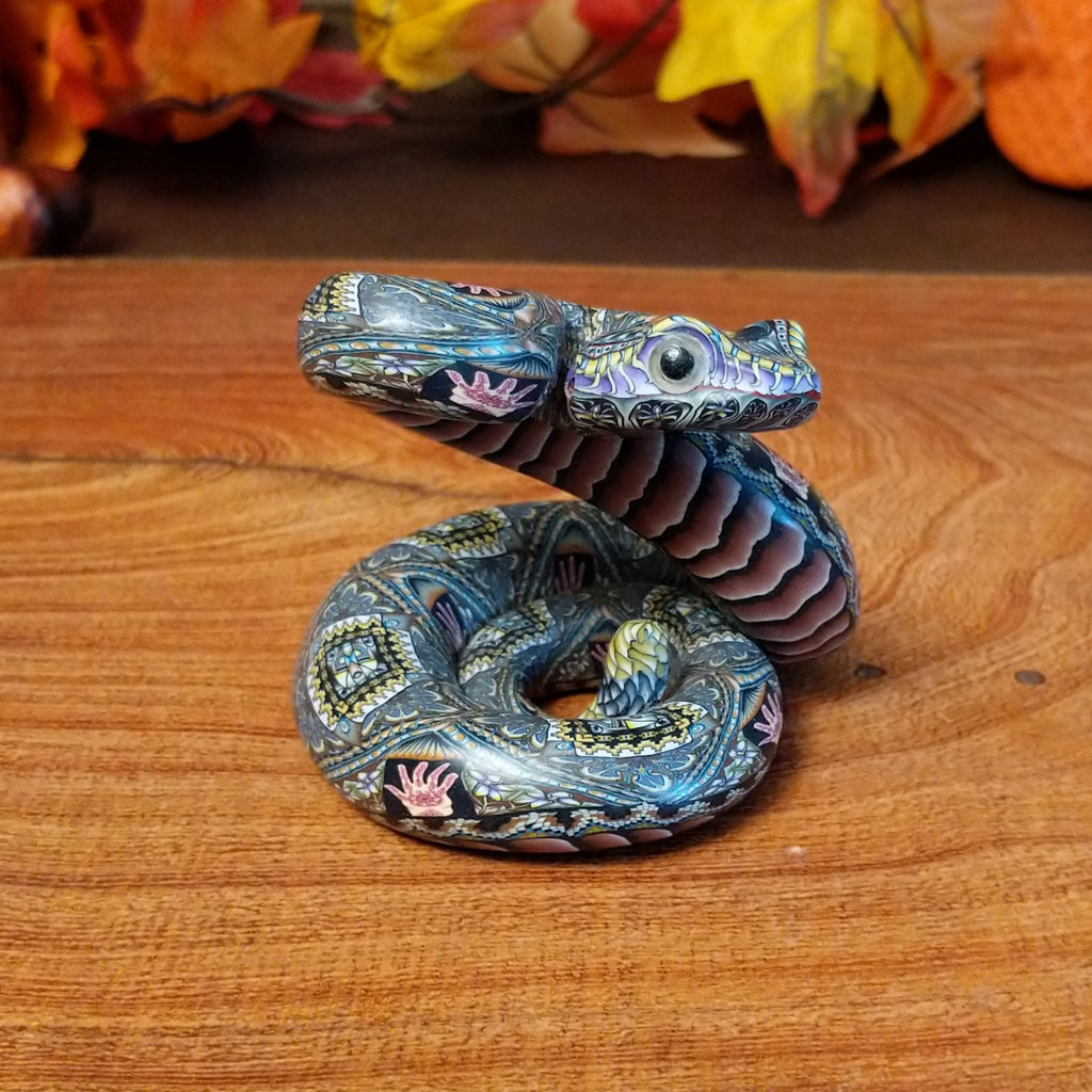 Polymer clay used to create a rattlesnake with colorful geometric and floral designs.