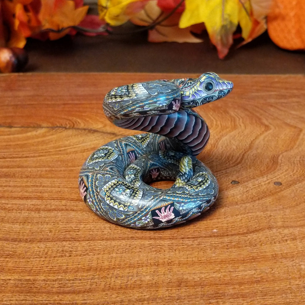 Polymer clay used to create a rattlesnake with colorful geometric and floral designs.