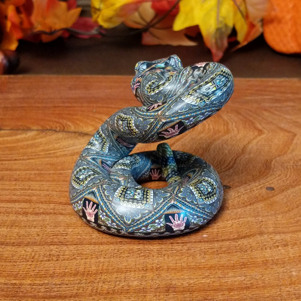 Polymer clay used to create a rattlesnake with colorful geometric and floral designs.