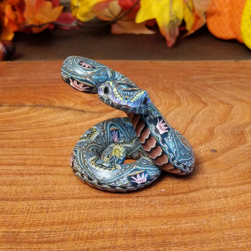 Polymer clay used to create a rattlesnake with colorful geometric and floral designs.