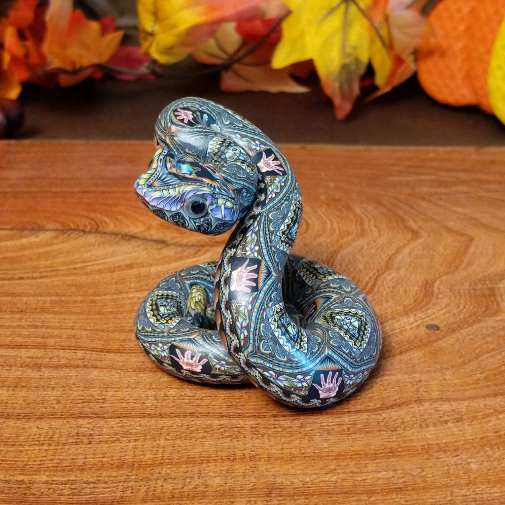 Polymer clay used to create a rattlesnake with colorful geometric and floral designs.