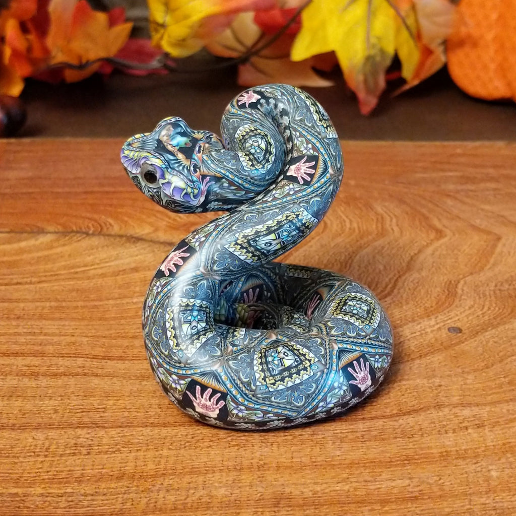 Polymer clay used to create a rattlesnake with colorful geometric and floral designs.