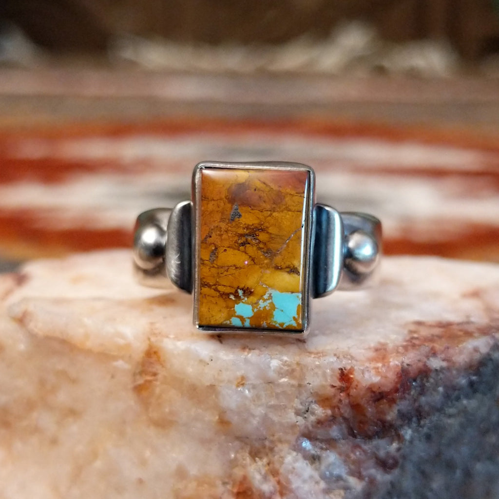 Rectangular boulder turquoise set within the bezel of the ring.