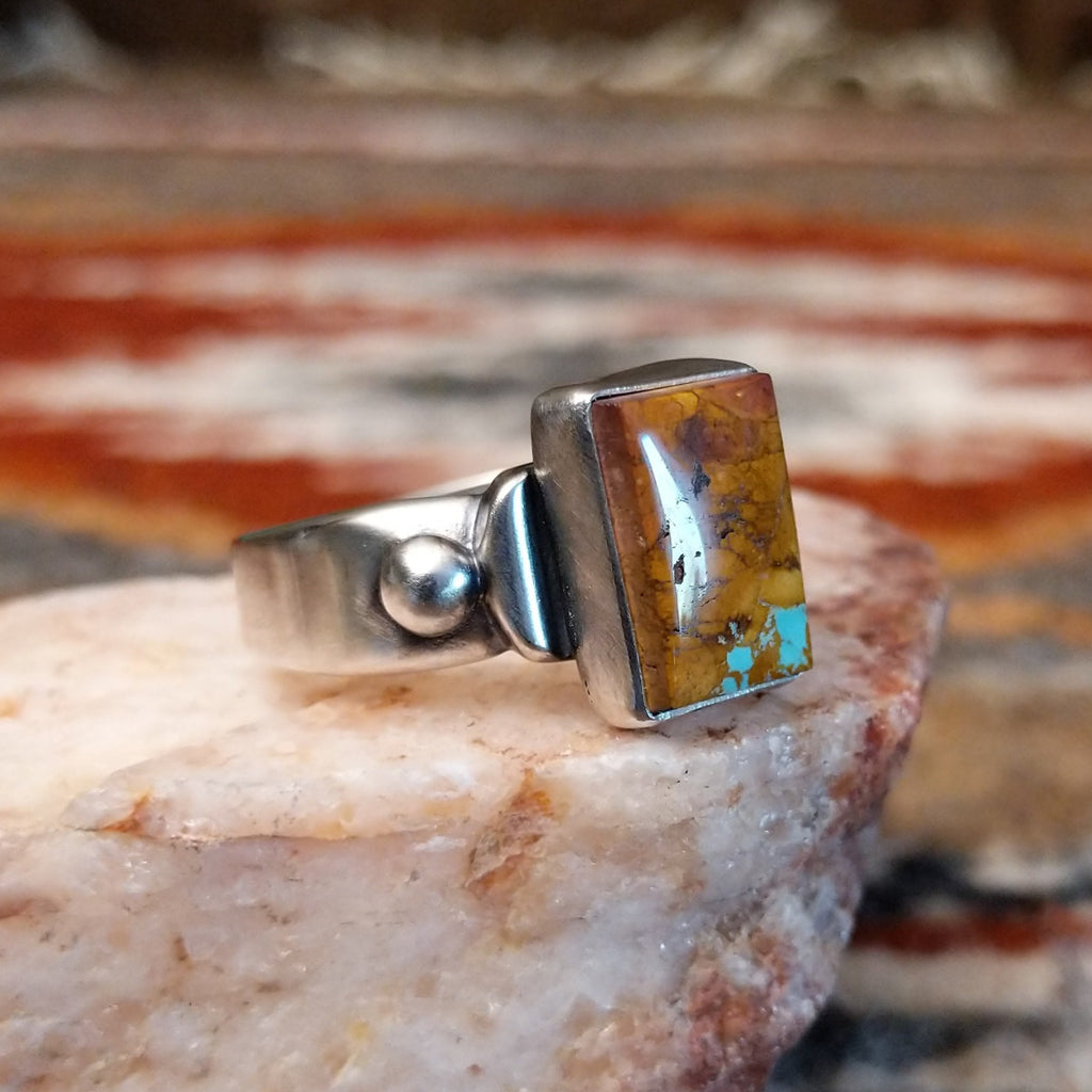 Rectangular boulder turquoise set within the bezel of the ring.