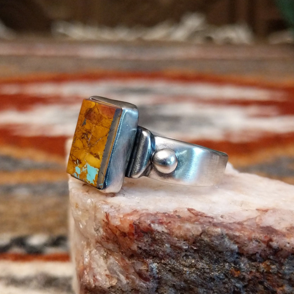 Rectangular boulder turquoise set within the bezel of the ring.