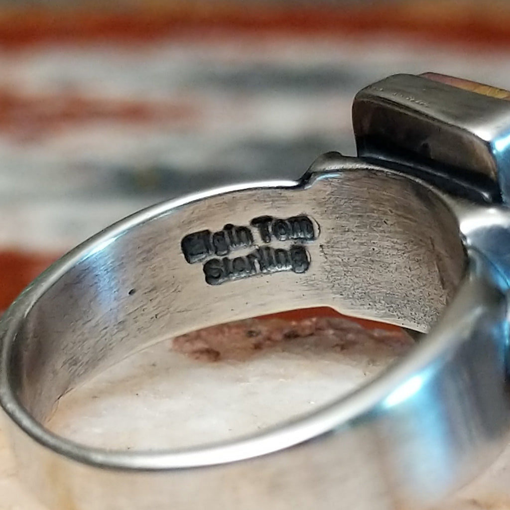 Close-up of the artisan's signature on the ring.
