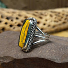 Rectangle bumblebee jasper ring by Terry Wood, featuring a vibrant rectangular bumblebee jasper stone with natural yellow, orange, black, and gray patterns set in a handcrafted sterling silver band.  Side view.