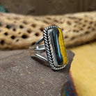 Rectangle bumblebee jasper ring by Terry Wood, featuring a vibrant rectangular bumblebee jasper stone with natural yellow, orange, black, and gray patterns set in a handcrafted sterling silver band.  Side view.