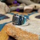 Sterling silver spiral ring by Raymond Coriz featuring a geometric stamped spiral design on a polished signet-style band with Southwestern craftsmanship; side view.