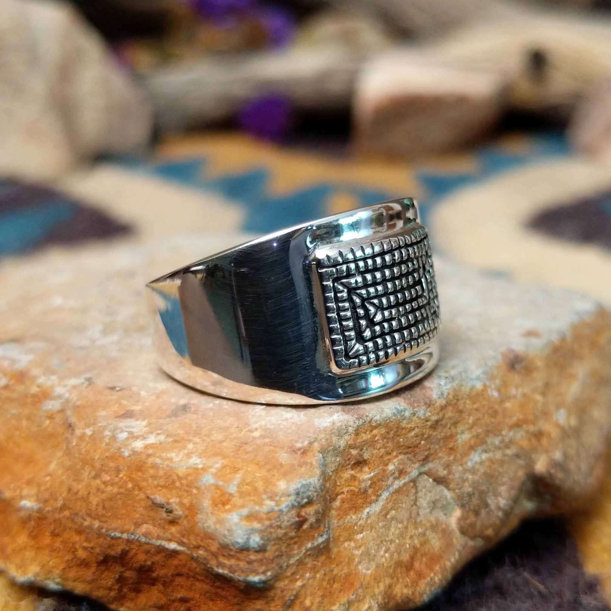 Sterling silver spiral ring by Raymond Coriz featuring a geometric stamped spiral design on a polished signet-style band with Southwestern craftsmanship; side view.