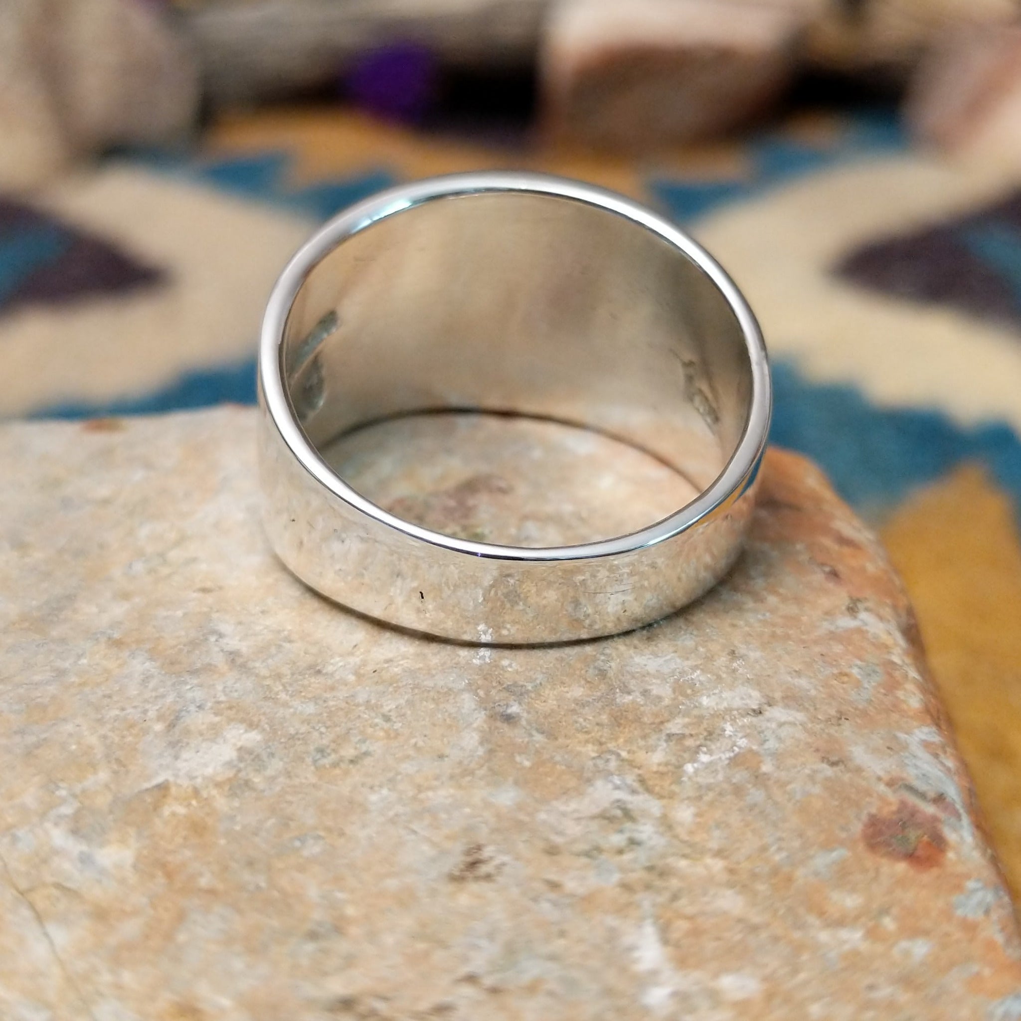 Sterling silver spiral ring by Raymond Coriz featuring a geometric stamped spiral design on a polished signet-style band with Southwestern craftsmanship; underside view.