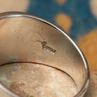 Sterling silver spiral ring by Raymond Coriz featuring a geometric stamped spiral design on a polished signet-style band with Southwestern craftsmanship; artisan stamp.