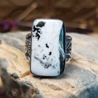 Sterling silver ring with white buffalo stone set in a rectangular bezel and stamped designs on the band.
