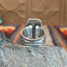 The ring's band is stamped with intricate details.
