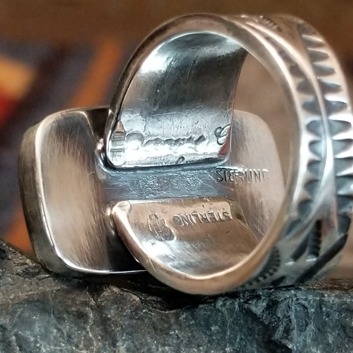 The artist's signature and authentication is found on the underside of the ring's band.