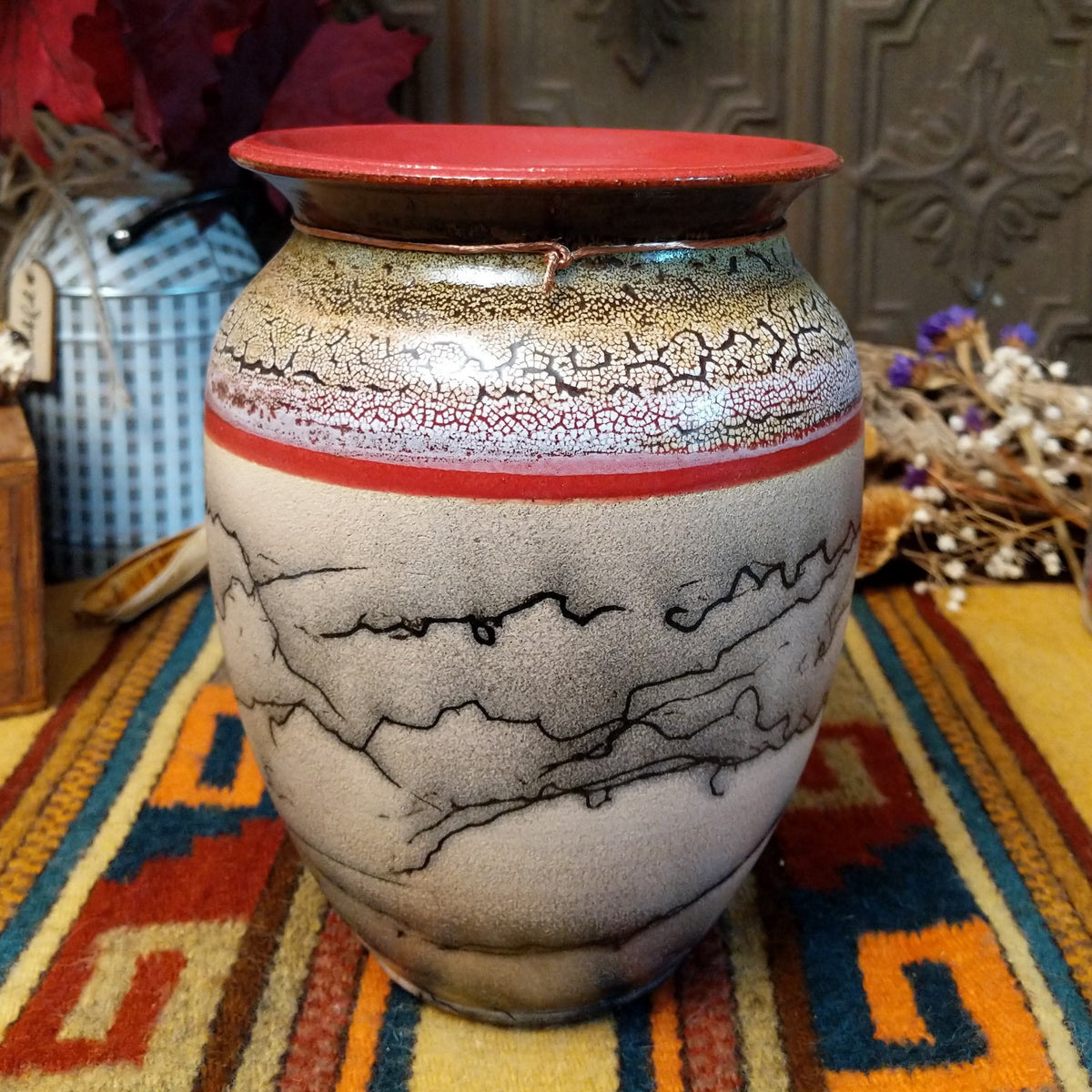 Rounded horsehair pottery vase by Roger Calhoun with a wide red rim, multicolored crackled shoulder, red accent band, and black horsehair markings across a cream-colored body.