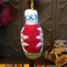 This charming Red Snowflake Bulb Wool Ornament by Ganz features a bright red wool body with a white snowflake design, blue accents, green and yellow bands near the bottom, a fluffy white top with blue stitching, and a gold hanging cord.