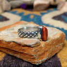Sterling silver Red Spiny Oyster Shell ring by Raymond Coriz with a hand-stamped band and oval red gemstone; side view.