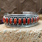 Sterling silver cuff bracelet with red spiny oyster shell set in oval bezels, lined along the surface and twisted rope with dotted accents.