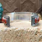Sterling silver cuff bracelet with red spiny oyster shell set in oval bezels, lined along the surface and twisted rope with dotted accents.