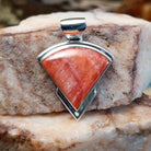 Sterling silver quarter circle pendant with red spiny oyster shell set in the bezel.