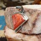Sterling silver quarter circle pendant with red spiny oyster shell set in the bezel.
