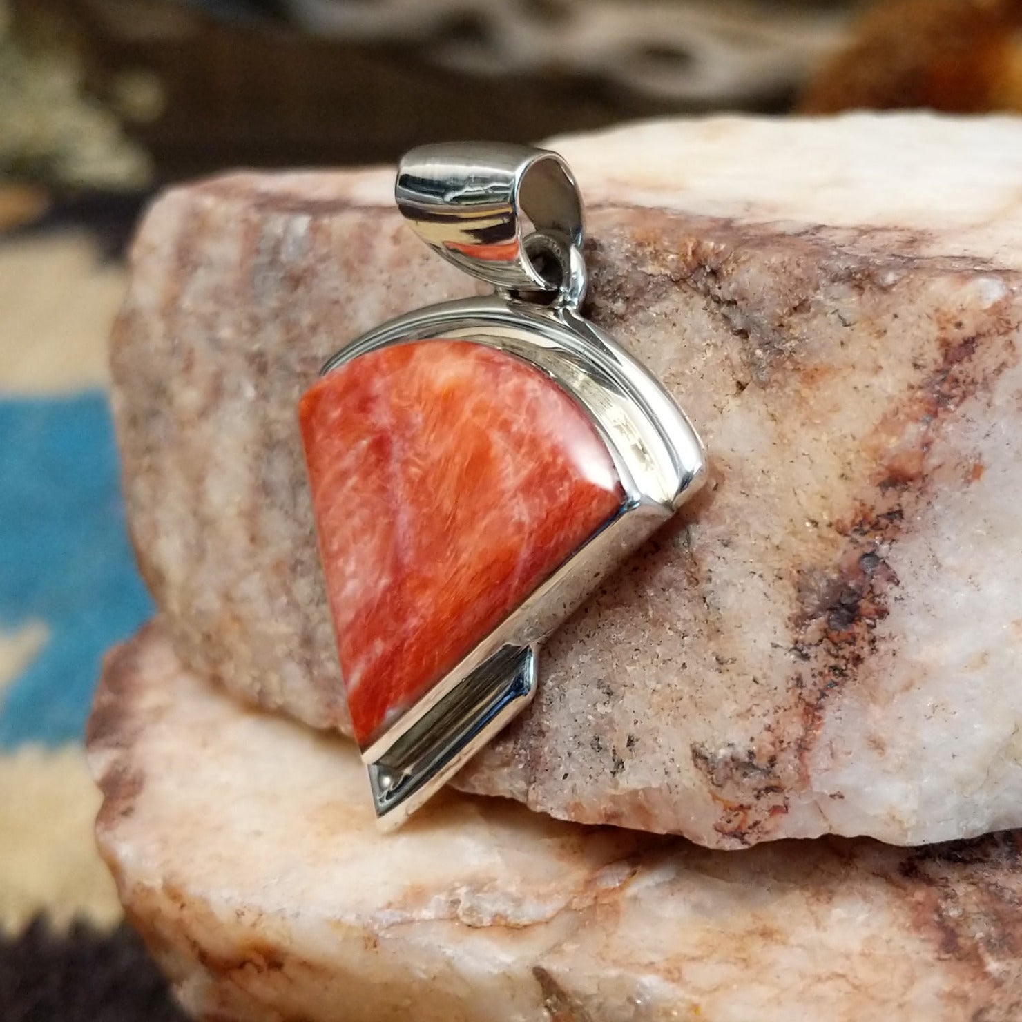 Sterling silver quarter circle pendant with red spiny oyster shell set in the bezel.