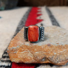 Red spiny oyster shell ring by Akee Douglas with five-row twisted silver band.