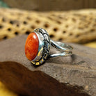 Red spiny oyster shell ring by Terry Wood, featuring a vibrant red spiny oyster shell set in a handcrafted sterling silver band with traditional Southwestern-inspired metalwork.  Side view.
