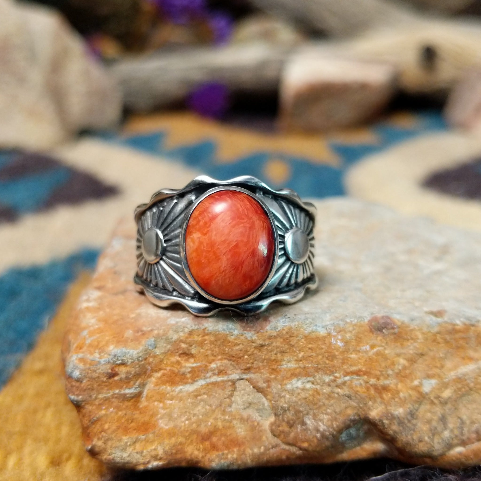 Sterling silver Red Spiny Oyster Shell ring by Raymond Coriz with an oval red and orange gemstone in a sunburst design.