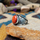 Sterling silver Red Spiny Oyster Shell ring by Raymond Coriz with an oval red and orange gemstone in a sunburst design; side view.