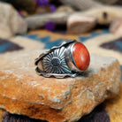 Sterling silver Red Spiny Oyster Shell ring by Raymond Coriz with an oval red and orange gemstone in a sunburst design; side view.